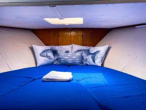 阿尔布费拉Stay in a Yacht - Algarve的配有枕头的客房内一张大蓝色的床