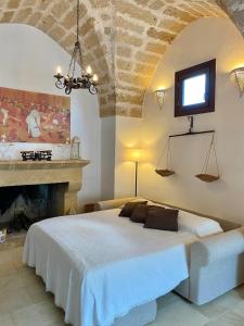 SquinzanoTenuta Afra的一间卧室设有一张大床和一个壁炉