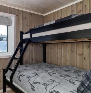 特吕西尔Beautiful cabin close to activities in Trysil, Trysilfjellet, with Sauna, 4 Bedrooms, 2 bathrooms and Wifi的配有木墙的客房内的双层床