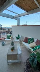卡斯泰拉马莱Casa Vacanze Gloria的天井设有沙发和桌子,享有海景。