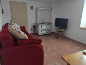 VignolaCasa Gemma的客厅配有红色沙发和电视