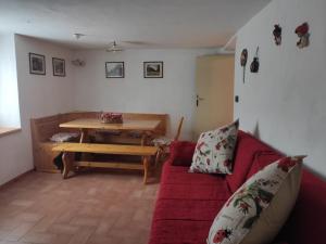 VignolaCasa Gemma的客厅配有红色的沙发和木桌
