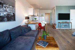 不莱梅Weserloft 21的一间带蓝色沙发的客厅和一间厨房