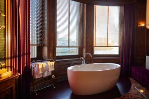 鹿特丹韦斯特考得酒店的一间带浴缸的浴室,位于带窗户的客房内