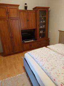 博加奇Evelin vendégház的一间卧室配有一张床和一个木制橱柜