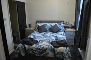 布里德灵顿Windmill Guest House的一张带蓝色和白色床单及枕头的床