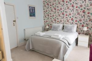滨海韦斯顿Rosita Guest House的一间卧室配有一张带花卉壁纸的床