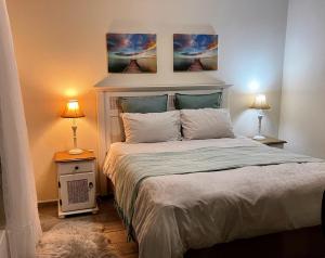 贝蒂湾Silverdunes - Seaview的一间卧室配有一张大床和两盏灯