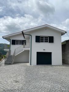 吉尔斯Cantinho Verde T3的白色的房子,上面有车库和楼梯