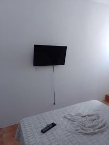 伊列乌斯Pousada bandeirantes的一张配有电视的床和遥控器
