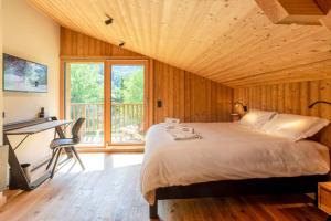 夏蒙尼-勃朗峰Chalet du Gouter - Chamonix All Year的一间卧室配有一张床、一张书桌和一个窗户。