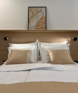 伊佐拉Zaro Apartments的一张配有白色床单和枕头的大床