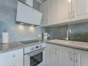 桑蒂亚戈德尔泰德Cosy Seaview Apartment的厨房配有白色橱柜和水槽