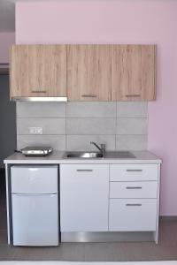 帕拉利亚卡泰里尼斯Giorgos-Fenia Apartments的厨房配有白色橱柜和水槽