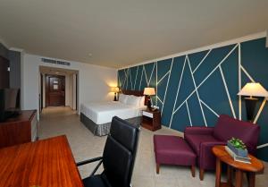 巴拿马城巴拿马皇冠假日酒店的酒店客房带一张床和紫色椅子