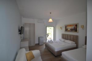 希马拉Bujtina Eleni的酒店客房,设有两张床和一张沙发