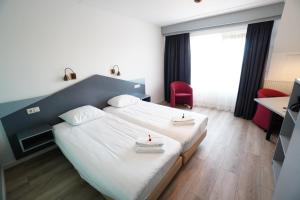 登堡Hotel Brasserie Den Burg的酒店客房配有两张床和一张书桌