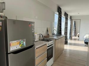 利马ACÉRCATE Aparts & Parking - BREÑA的厨房配有冰箱和炉灶。 顶部烤箱