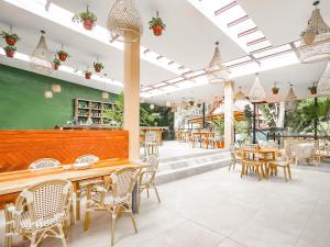 下博克特Selina Boquete的餐厅设有木桌和椅子,拥有绿色的墙壁