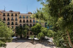 马德里Living Plaza de la Paja的前面设有桌椅的建筑