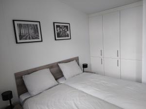 LathumLathumlodge met parkvoorzieningen的白色卧室配有带2个枕头的床