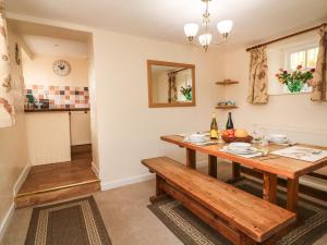 曼海德Hedgehog Cottage的厨房以及带木桌的用餐室。