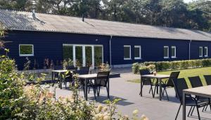 Loon op ZandHotel B&B Buiten Loon的花园内带桌椅的蓝色建筑