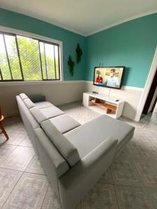 瓜鲁雅Apartamento no Guarujá, a poucos minutos da praia的带沙发和电视的客厅