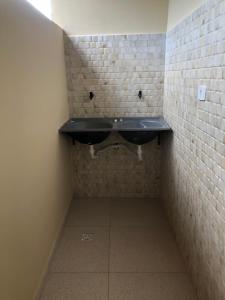 帕尔梅拉斯Residencial e Chalés Cristal的砖墙内带黑色水槽的浴室