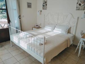 尼欧克利马Nostra Casa di Hovolo的一间卧室配有一张白色床架的床