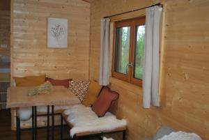蒙特-圣-奥博特La Roulotte des Mohuques的小木屋设有桌子和窗户。