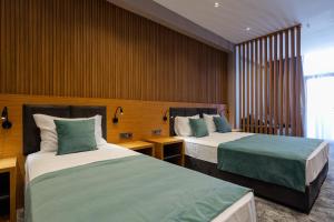 巴统Hotel Monarch的酒店客房,配有两张带绿床单的床