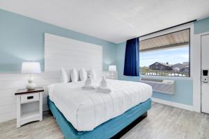 斩魔山约翰·扬西海滨酒店的一间卧室设有一张大床和一个大窗户