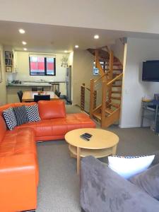 斯瑞德伯Angala 1 Lovely Woodridge 2-Bedroom Apartment的客厅配有橙色沙发和桌子
