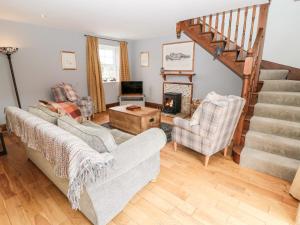 莫珀斯Sarah's Cottage的客厅设有两张沙发和一个楼梯