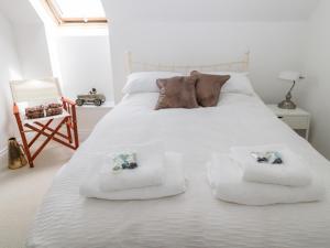 莫珀斯Sarah's Cottage的卧室配有白色床和毛巾