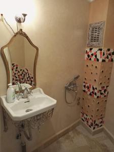 舍夫沙万RIAD LA SANTA的一间带水槽、镜子和淋浴的浴室