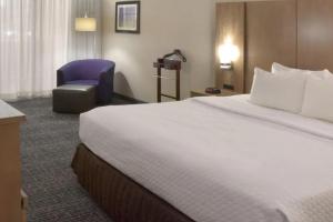 米德尔堡海茨克利夫兰机场皇冠假日广场的酒店客房带一张大床和一把椅子