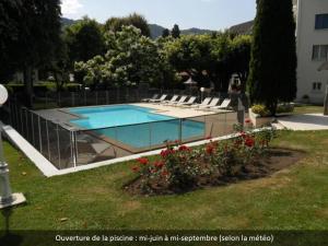 塞尔河畔维克Hotel Beauséjour的庭院内带躺椅的游泳池