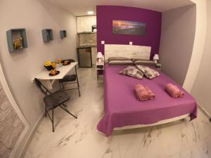 科孚镇MEMORIA的一间卧室配有一张紫色的床和一张桌子
