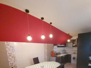 比斯特里察Rhs Host的厨房配有红色墙壁,桌子上方灯火