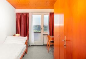 HembergHotel Swiss Views的一间卧室设有床、窗户和门