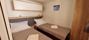 巴什卡沃达TAKE IT EASY Mobile Home, Camp Basko Polje #New2022的小房间设有两张床和窗户