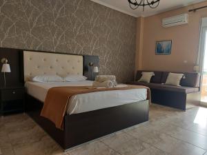 尼亚·卡利克拉提亚Hotel Epavli的一间卧室配有一张大床和一张沙发