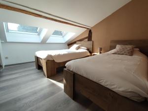 GouvyB&B Emmylou的一间卧室设有两张床和两个天窗。