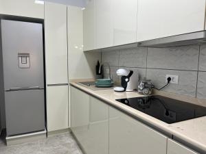 马马亚Sunset Lake Apartments - Mamaia Nord的厨房配有白色橱柜和水槽