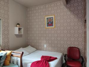 里约布兰科Condomínio DINASEG的一间卧室配有一张床和一张红色椅子