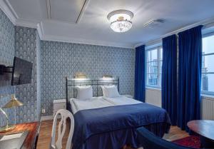 斯德哥尔摩斯堪迪克格姆拉斯坦酒店的一间卧室配有一张带蓝色棉被的床