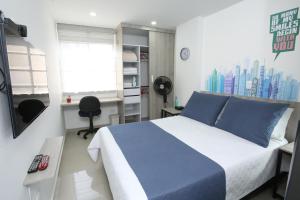 麦德林New Studio Apartment for Two的卧室配有蓝色和白色的床和窗户。