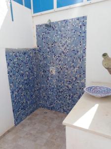 乌姆苏克Maison typiques (houche) avec piscine的带淋浴的浴室(带蓝色瓷砖墙)
